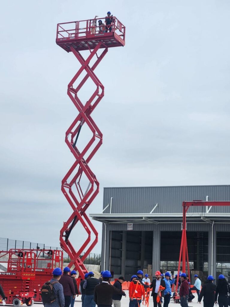 Plataforma de elevación roja LGMG Plataforma de elevación roja de tijera abierta en un almacén